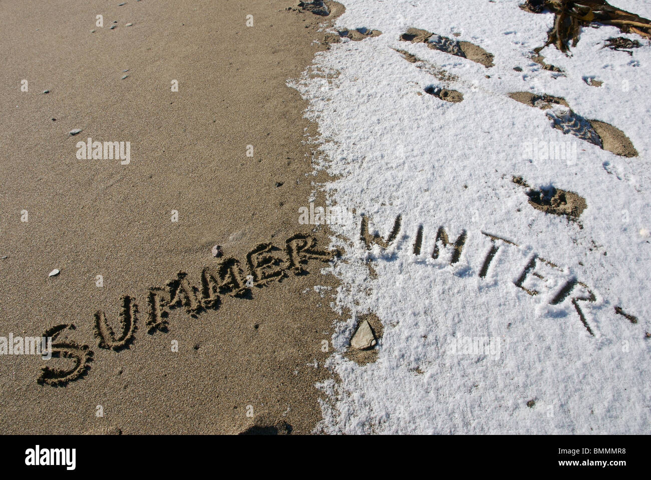 Sommer und Winter Worte geschrieben in Sand und Schnee am Strand, Devon, UK Stockfoto