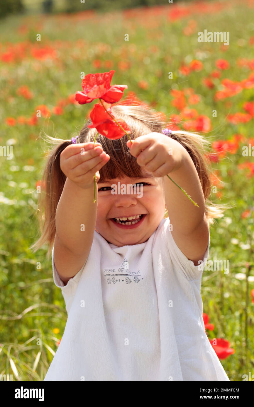 Kleines Mädchen mit Mohnblumen. Stockfoto