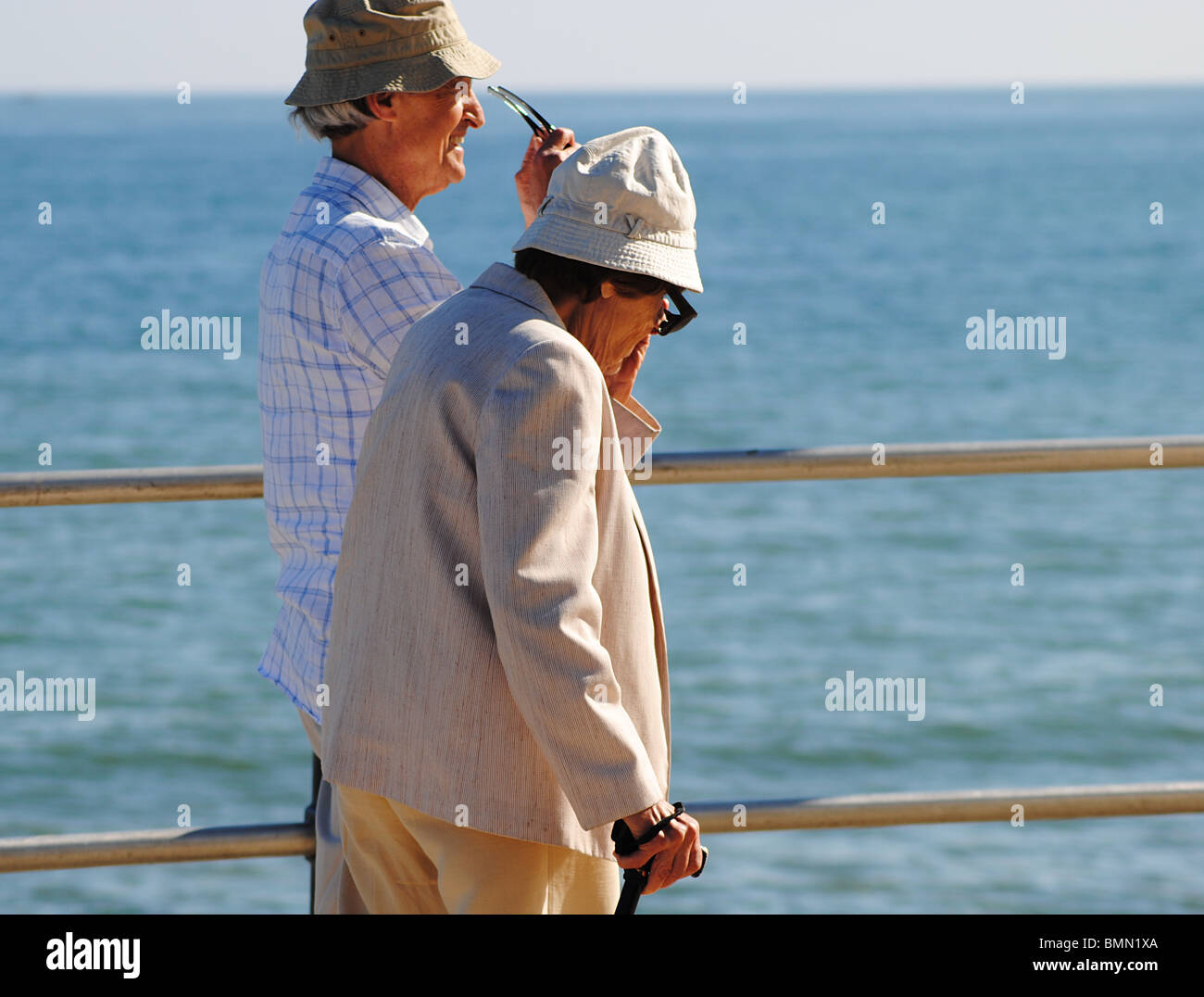 Ein älteres Ehepaar Fuß entlang der Strandpromenade in Charmouth, Jurassic Coast, Dorset, England Stockfoto