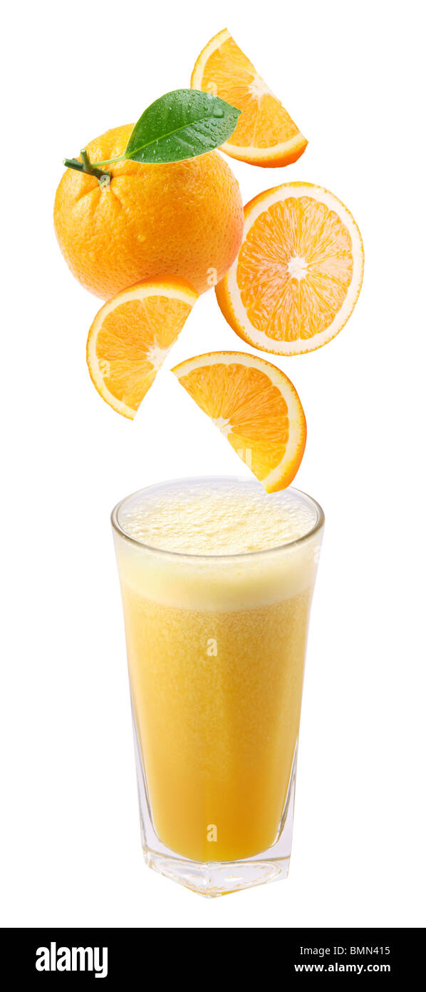 Scheiben von Orange fallen in ein Glas frischen Orangensaft Stockfoto