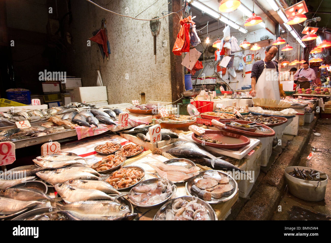 Mann verkaufte Fische und Meeresfrüchte im Fischgeschäft im Fischmarkt in Hong Kong Stockfoto