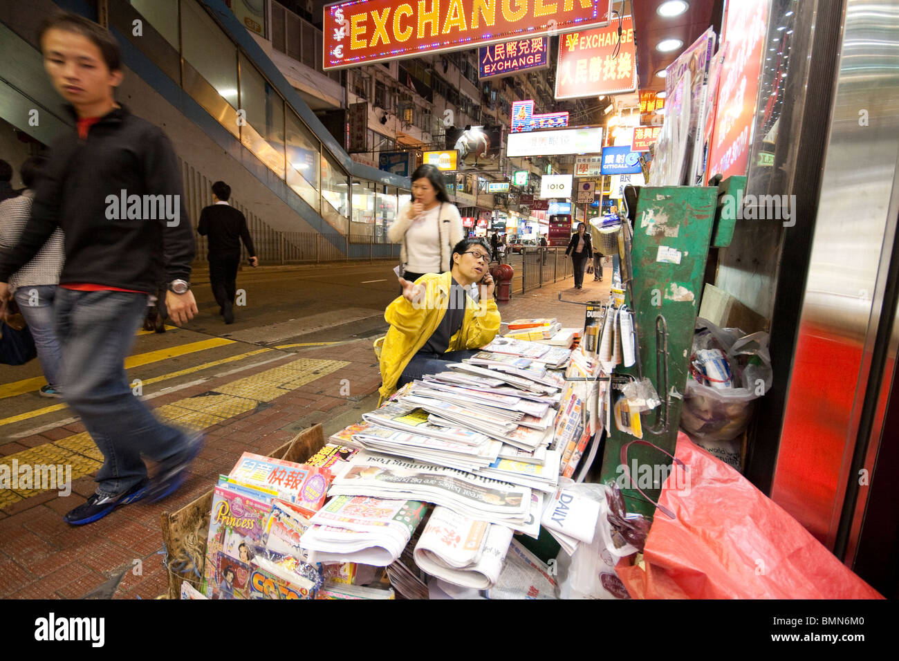 Man verkaufte Zeitungen und Magazine auch telefonieren mit Handy in Hongkong Stockfoto