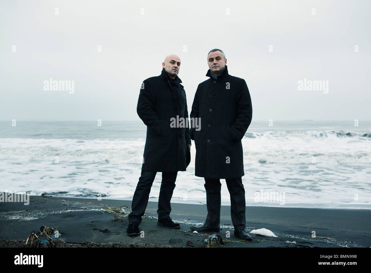 Zwei Männer in dunklen Mänteln auf Winter Strand Stockfoto