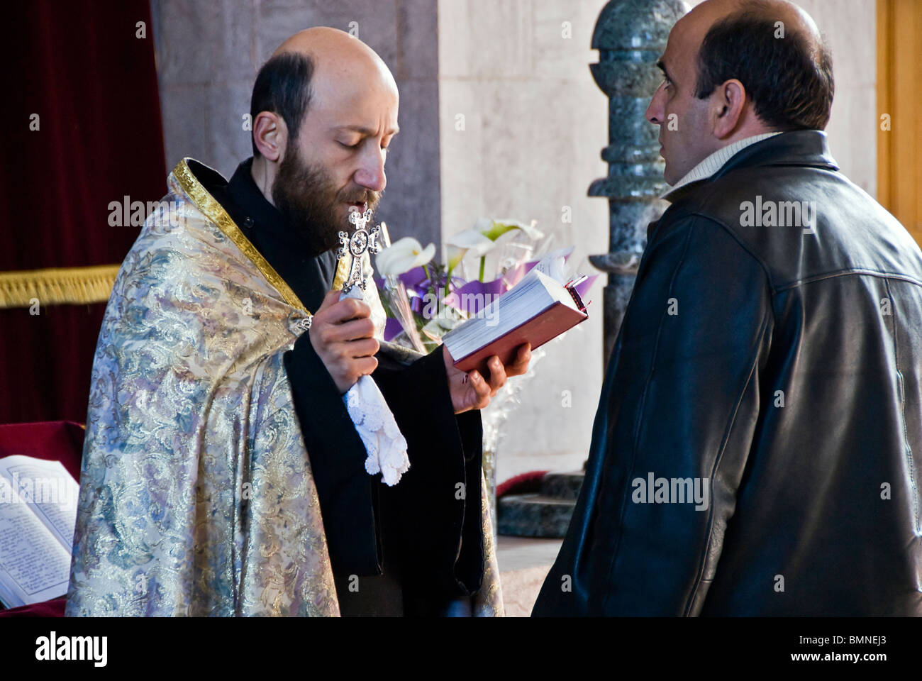 Priester taufte einen erwachsenen Mann in einer orthodoxen Kirche in Armenien. Stockfoto