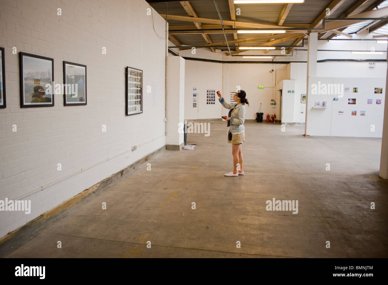 London, England, Großbritannien, Teen besuchen die zeitgenössische Kunstgalerie, Old Trueman Brewery, Spitalfields Mar-Ket, eine Frau ALLEIN im Haus, Leute, die Fotos in der Galerie machen Stockfoto