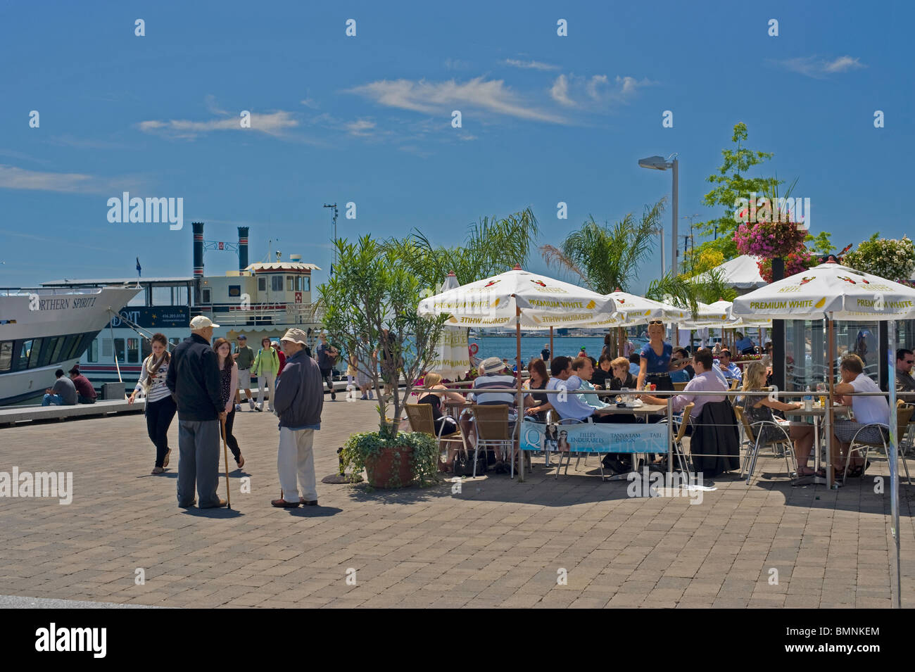 Cafe Gönner und Fußgänger am Queens Quay, Toronto.  Harbourfront Innenhöfe sind beliebte Orte für Touristen und Einheimische. Stockfoto