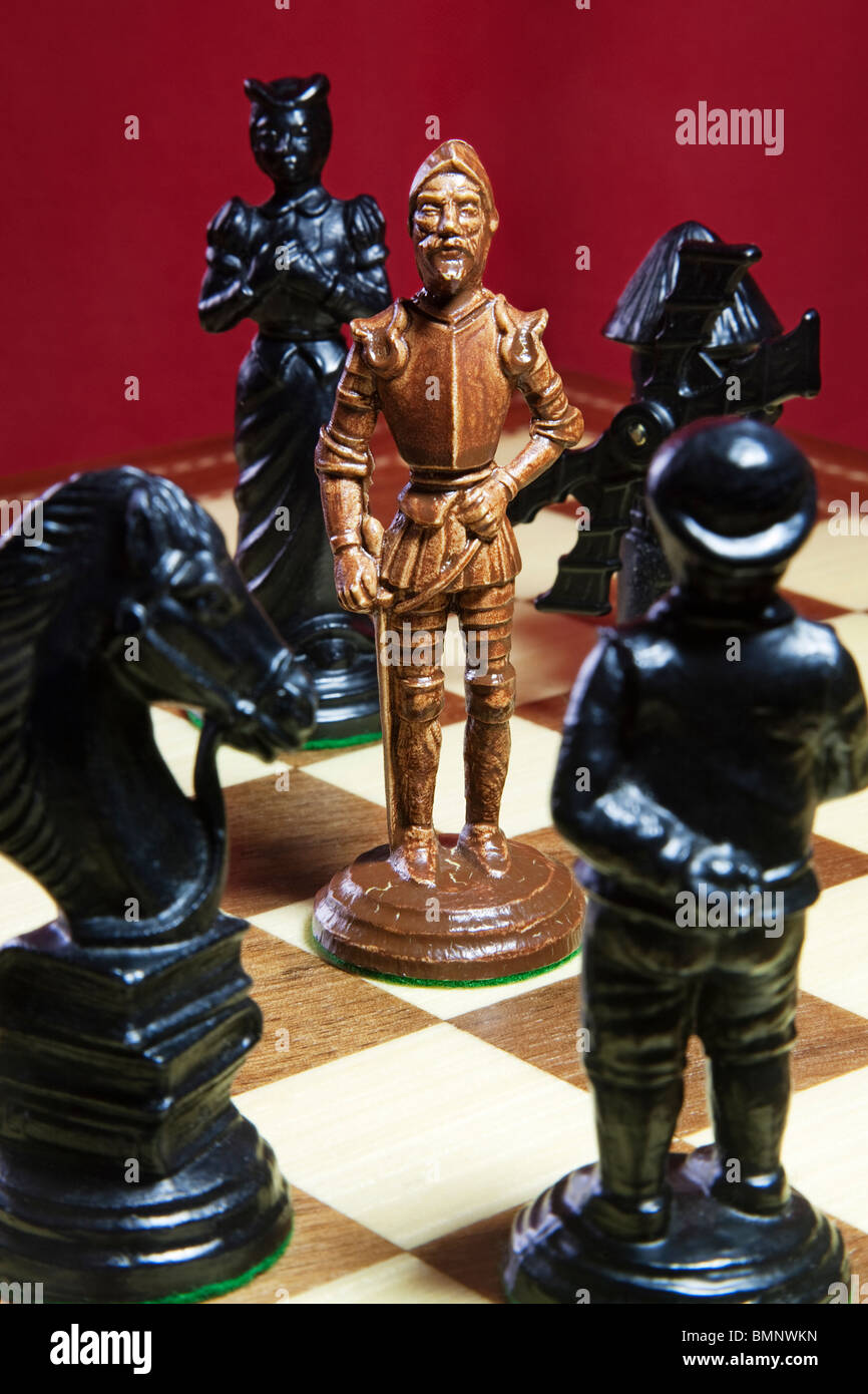 Eine weiße Schachkönig umgeben von schwarzen Figuren am Ende eines Spiels. Stockfoto