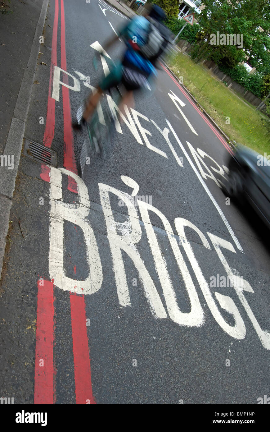 verschwommene Radfahrer überqueren eine Straßenmarkierung zeigt eine Route nach Putney Bridge, Südwesten von London, england Stockfoto