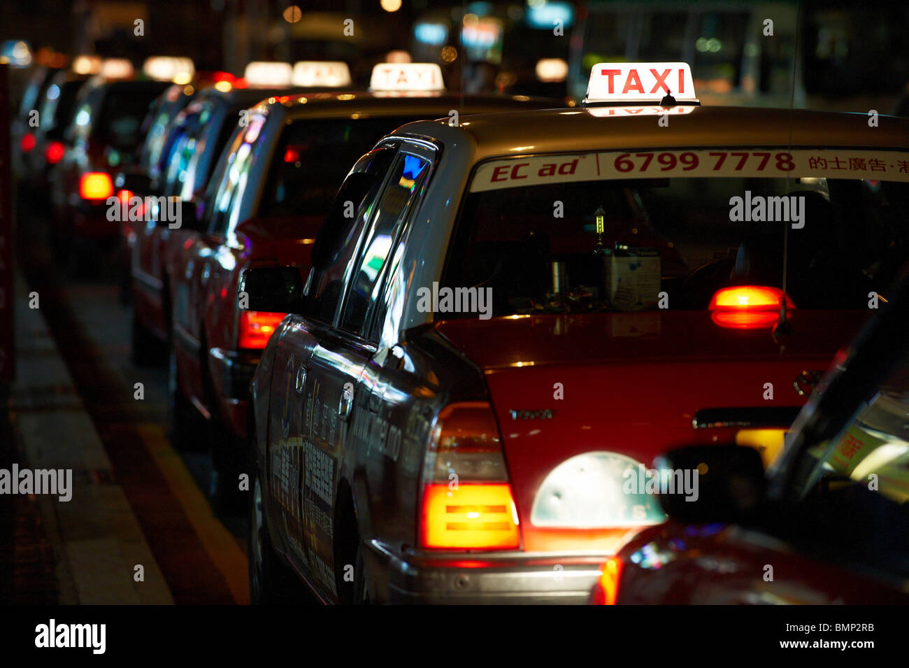Taxis in eine Warteschlange für Kunden in der Nacht, mit leuchtenden Lichtern auf aufgereiht. Stockfoto