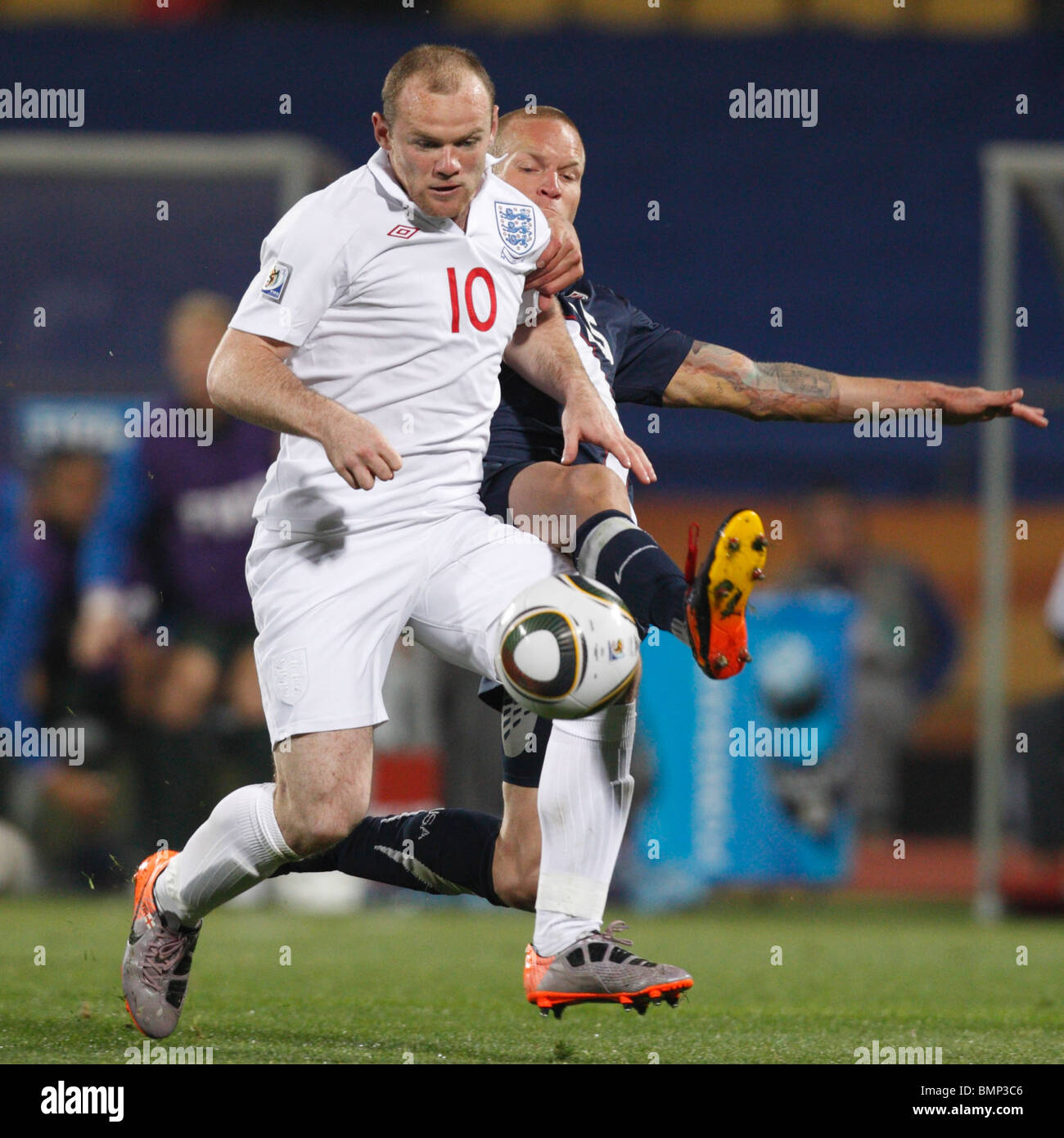 Wayne Rooney England (10) Angriffe auf die Vereinigten Staaten als Jay DeMerit (r) verteidigt während eines Fußballspiels 2010 World Cup Stockfoto