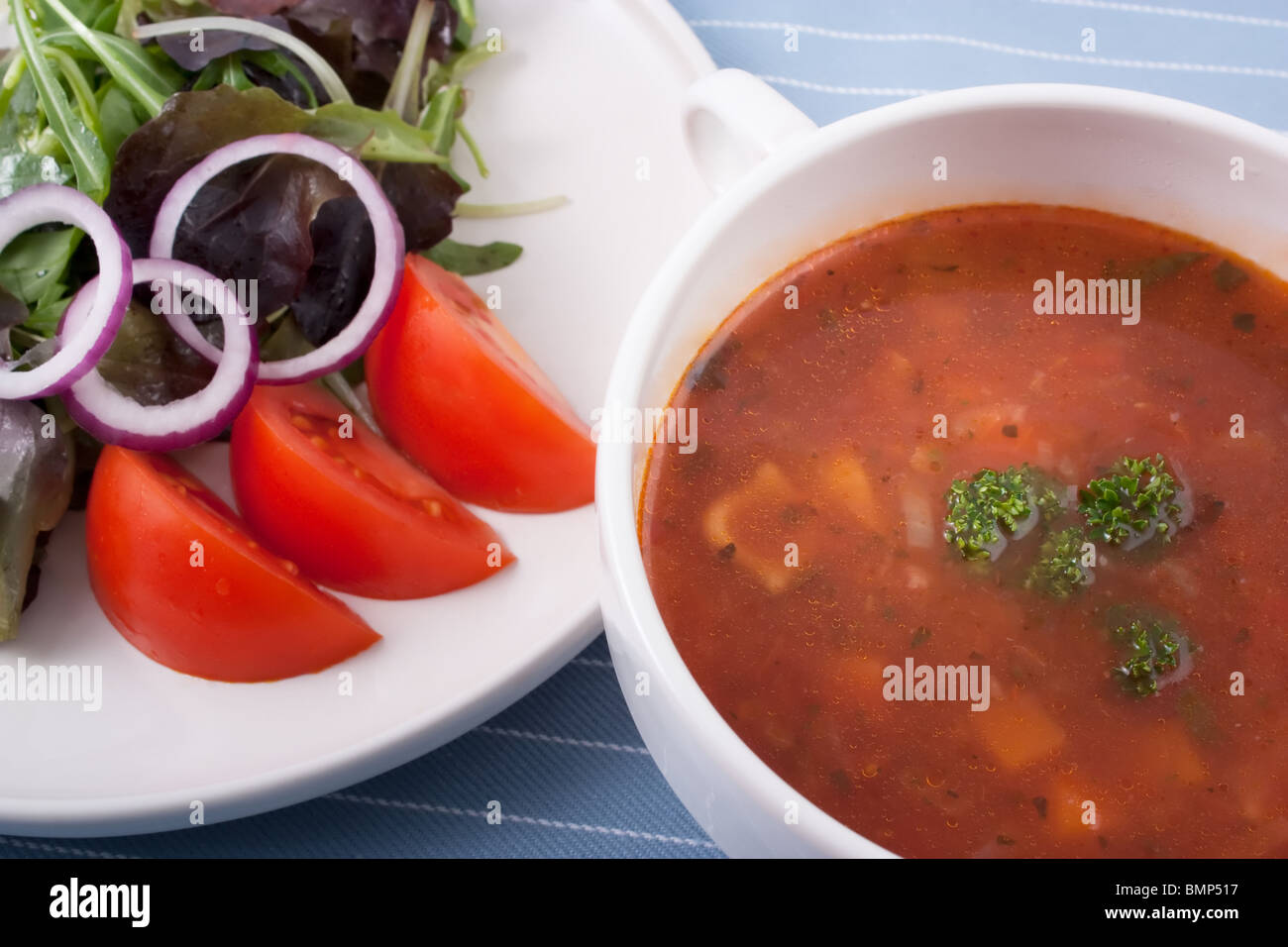 Minestrone-Suppe und Salat. Stockfoto