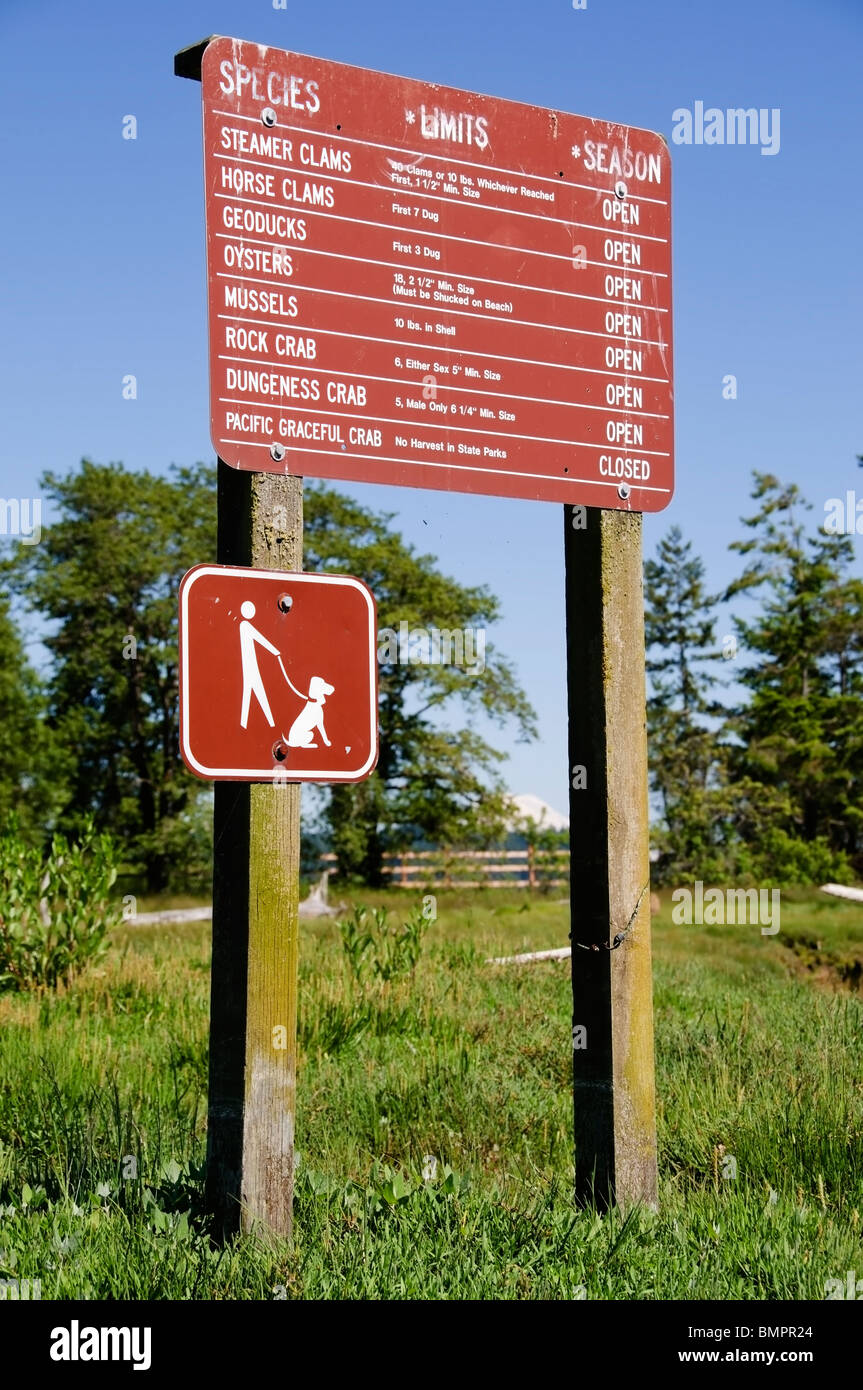 Ein großes Schild auf McMicken Island State Park führt die Regeln und Vorschriften über die Ernte, Krabben und Muscheln am Ufer. Stockfoto