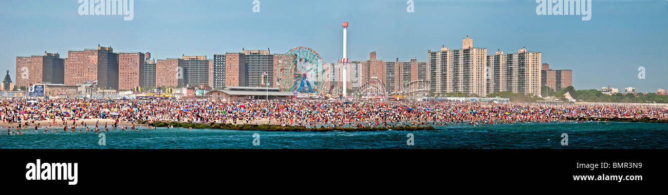 Eine Urlaub-Menge von mehr als 1 Million sonnt sich und schwimmt am Strand der berühmten Vergnügungspark Coney Island in Brooklyn, NYC Stockfoto