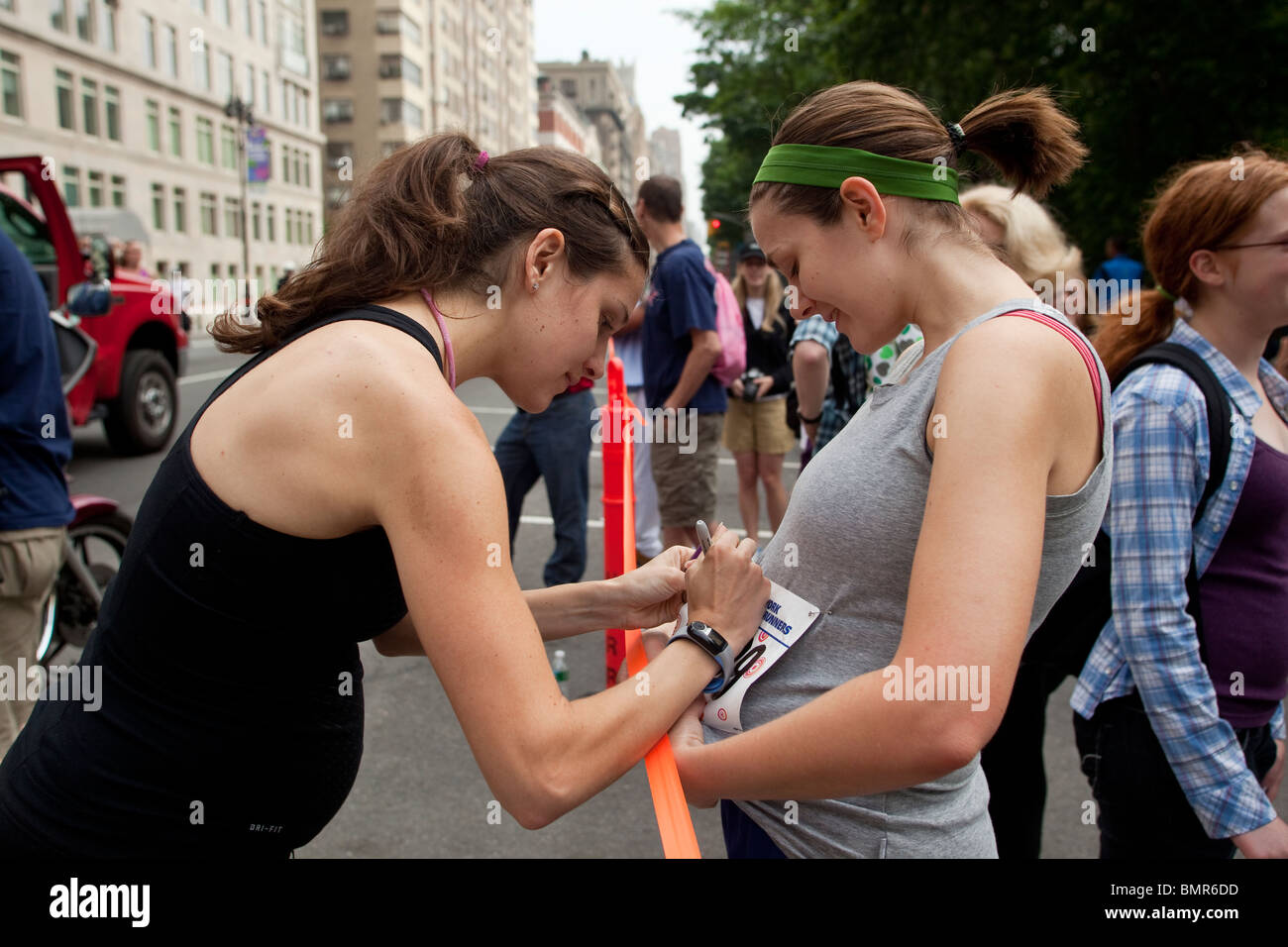 Eine schwangere Kara Goucher (USA) unterzeichnen ein Autogramm für einen anderen Läufer in der 2010 New York Mini 10K. Stockfoto
