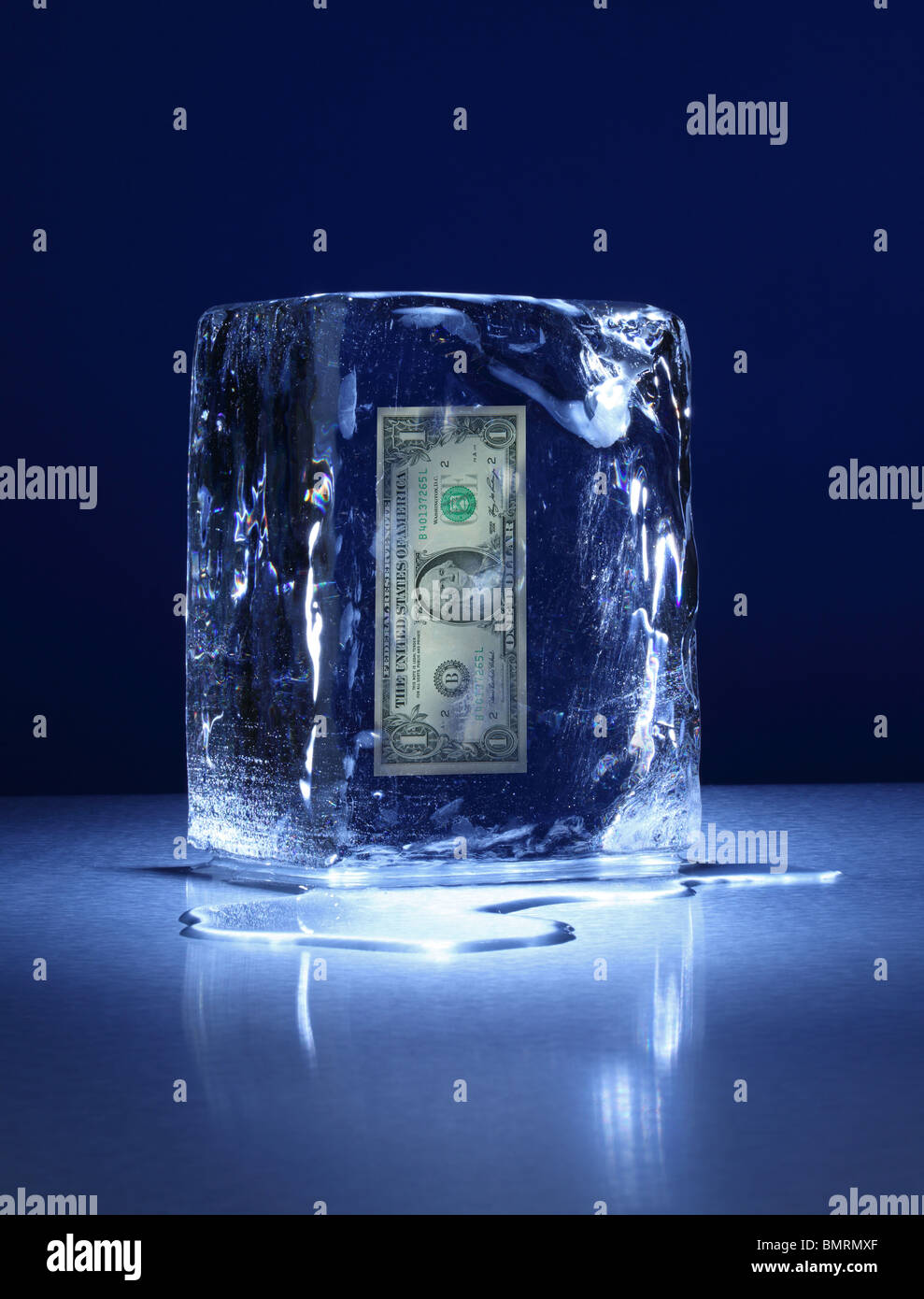 Einen gefrorenen Eisblock auf einer Metalloberfläche mit einer Banknote ein USD im Inneren Stockfoto