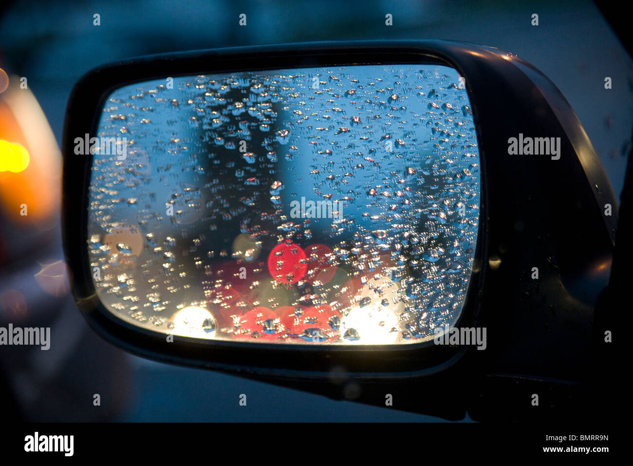 Seitenspiegel auf einem blauen auto mit regentropfen