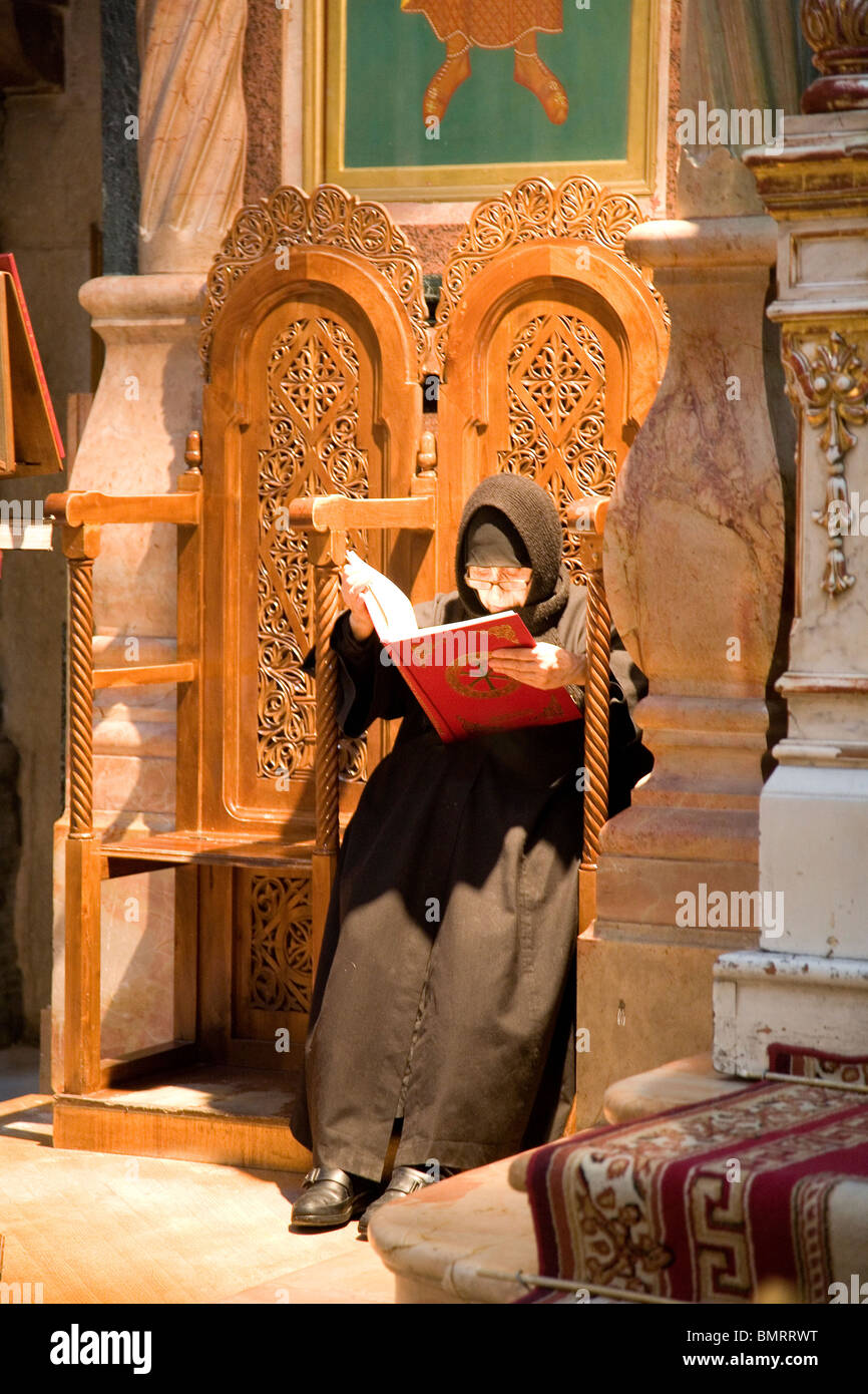 Nonne lesen Bibel in griechisch orthodoxen Kirche / Kapelle in der Kirche von der Grabeskirche in Jerusalem Stockfoto