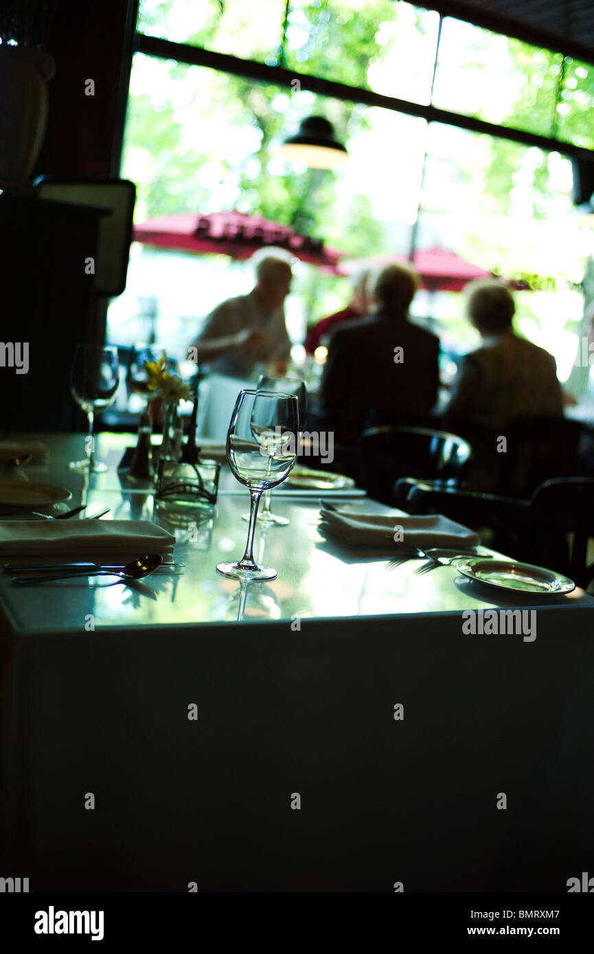 Tischdekoration auf leeren Bistro-Tisch mit Tisch von Gönnern Silhouette gegen Fenster. Stockfoto