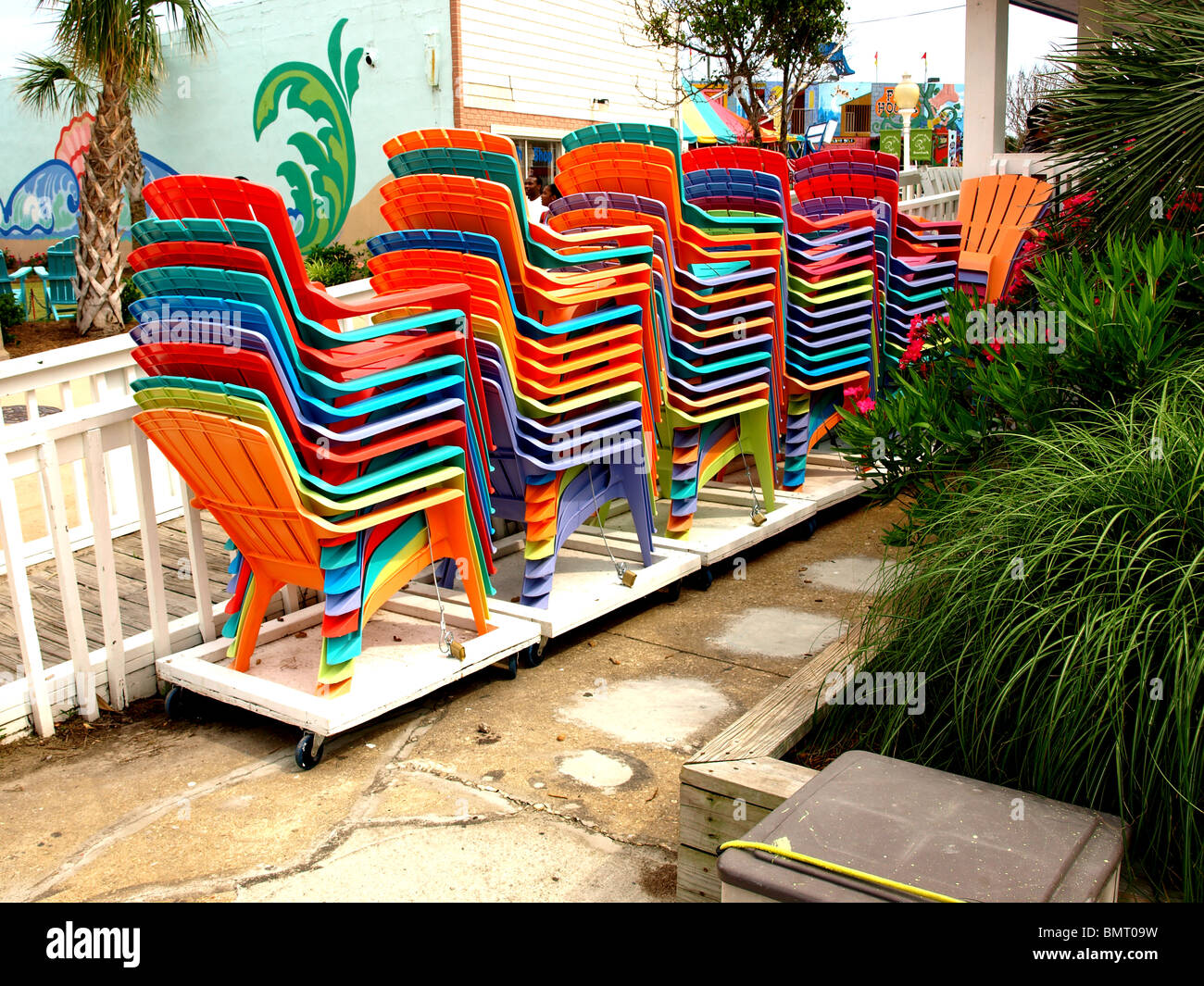 Kunststoff Stapeln Stühle in Pfähle mehrere Farben auf Plattform im freien Stockfoto