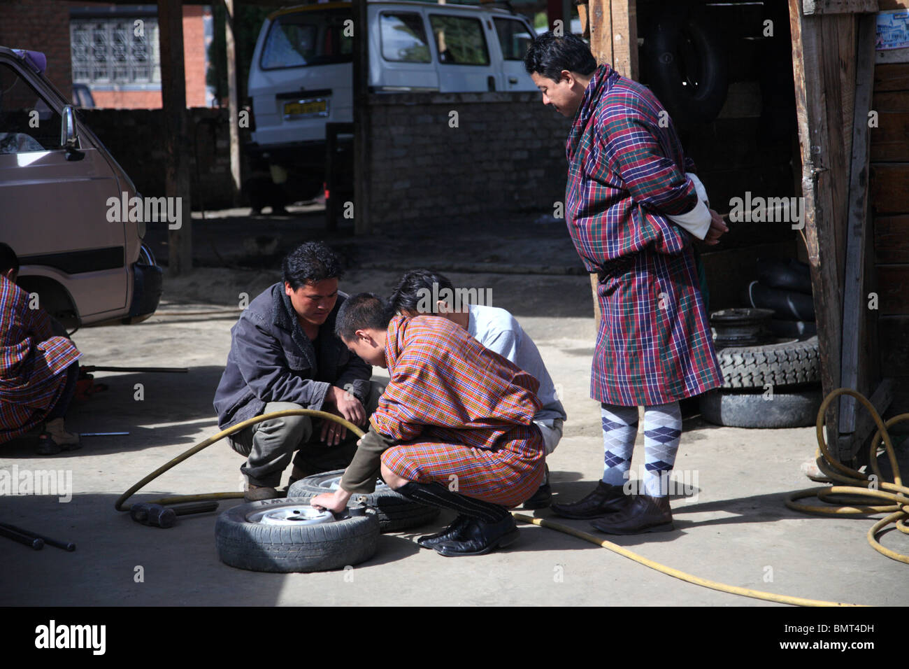 Kfz-Mechaniker zur Festsetzung einer Reifenpanne in Paro, Bhutan. Stockfoto