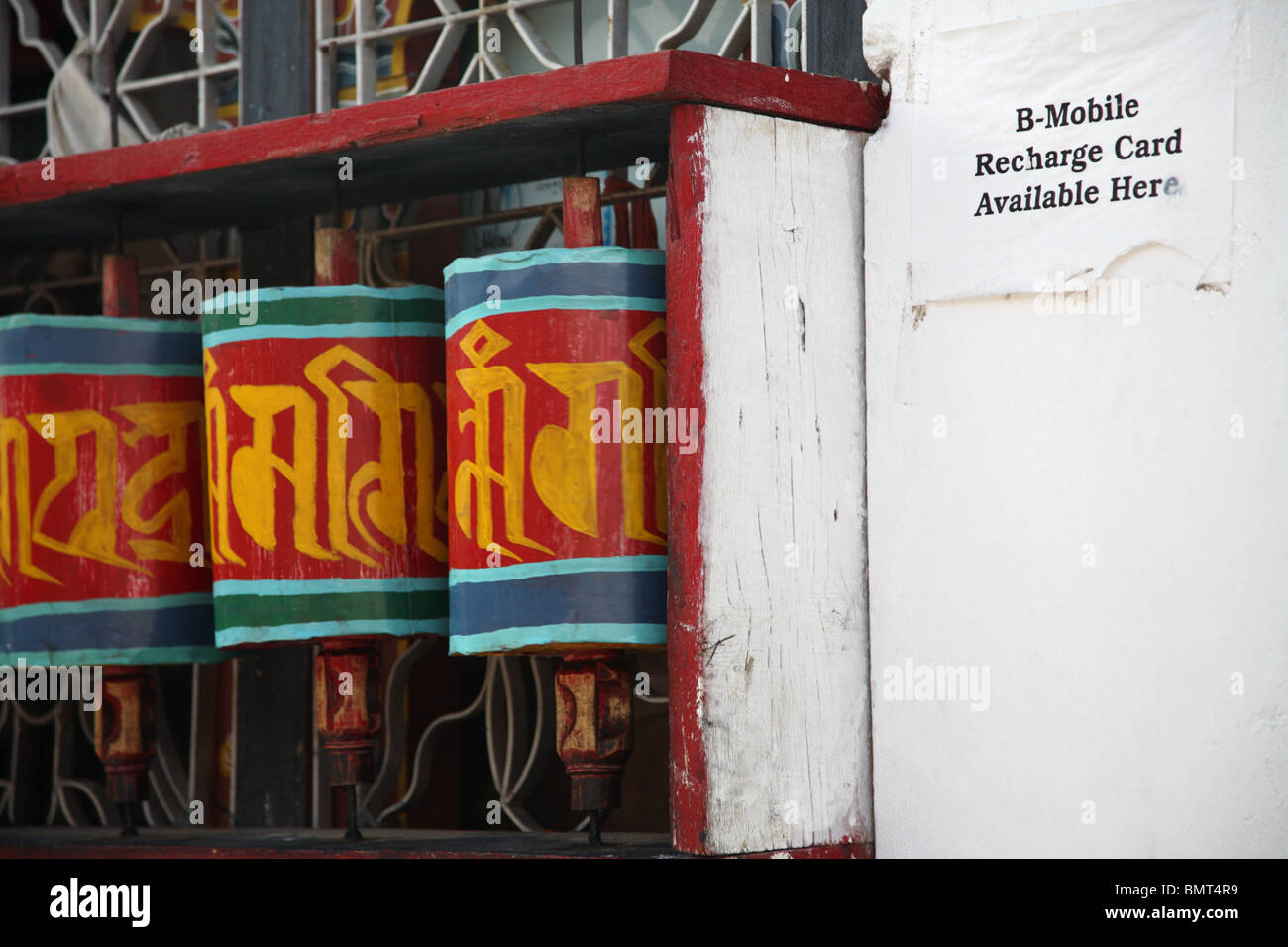 Buddhistische Gebetsmühlen neben einem Mobiltelefon bemerken in Paro, Bhutan. Stockfoto
