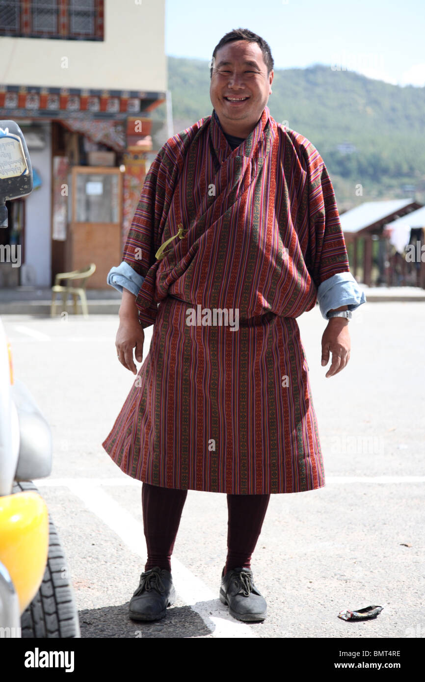 Ein grinsender Taxifahrer zeichnet sich durch sein Fahrzeug in Paro, Bhutan. Stockfoto