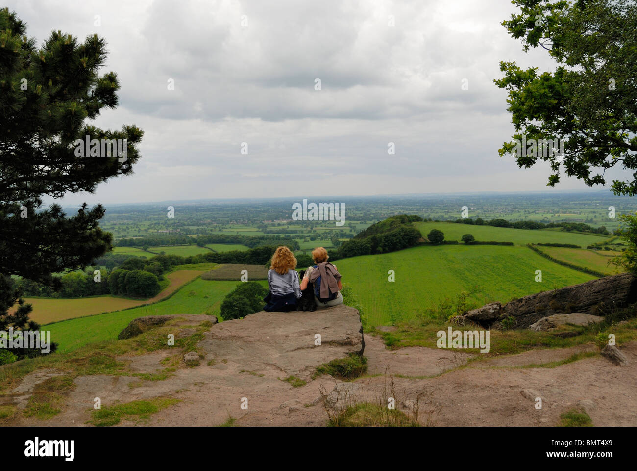 Walker mit Karte genießen Sie den Blick über den Cheshire-Ebenen aus dem Sandstein-Pfad. Stockfoto
