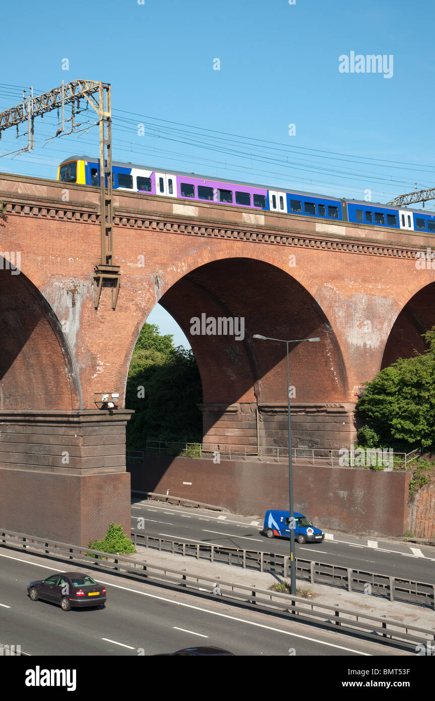 Zug fährt in Stockport Viadukt mit Autobahn M60. Stockfoto