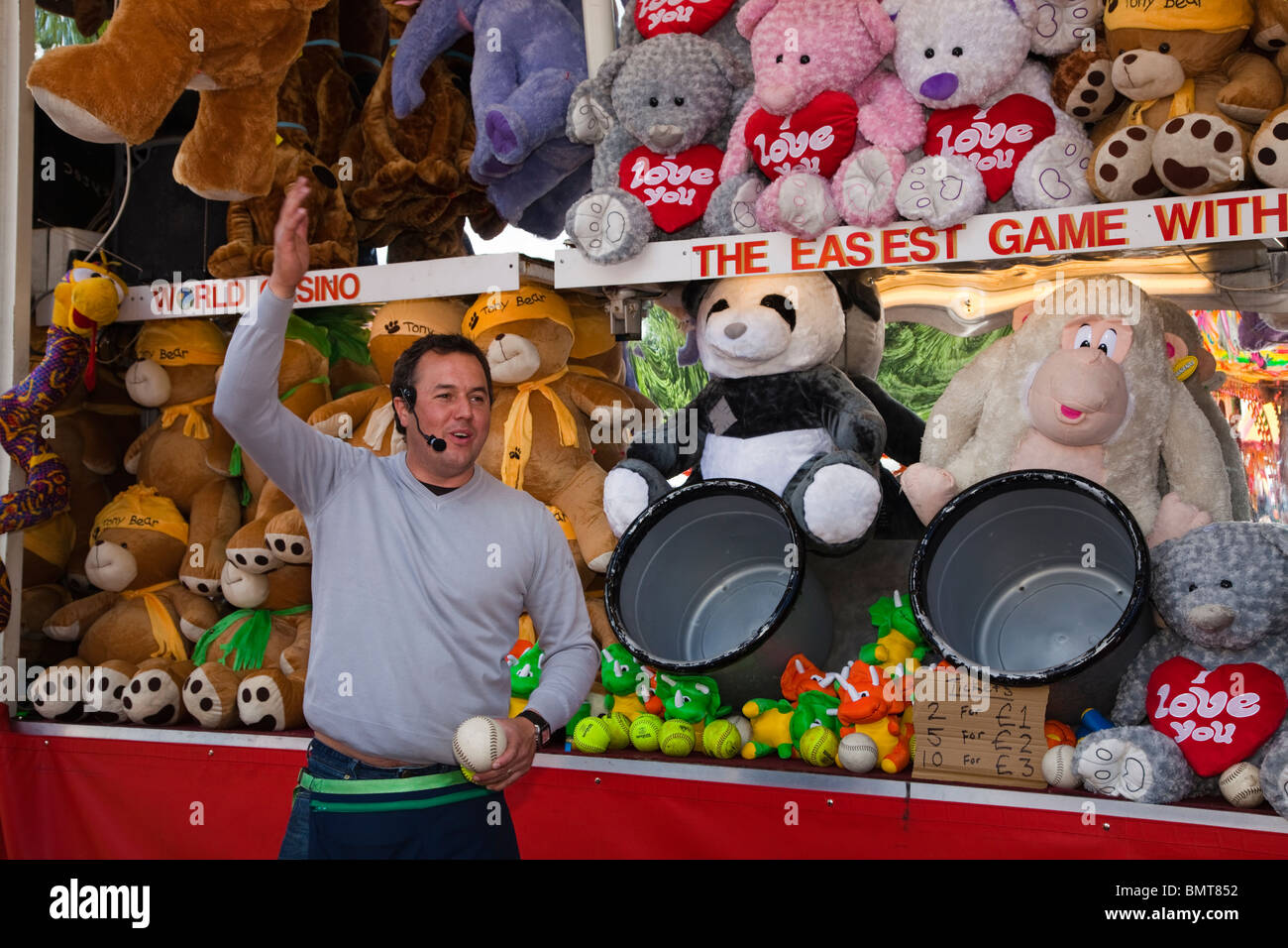 Mann auf einem Rummelplatz Stall wo Sie einen Ball in einen Eimer werfen zu  gewinnen, ein Teddybär, West End Festival, Glasgow, Scotland, UK  Stockfotografie - Alamy