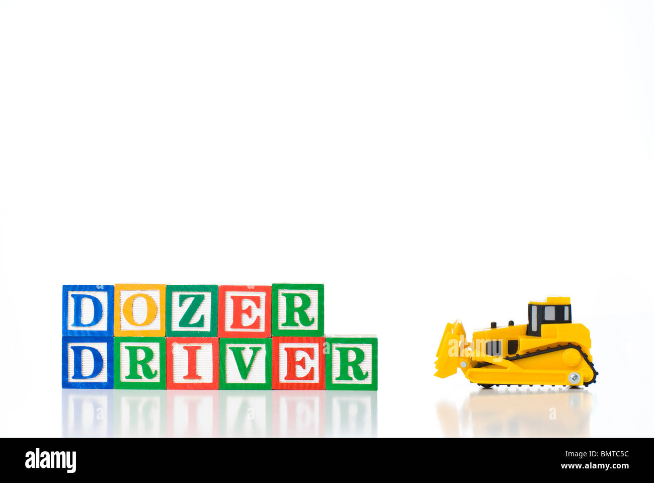 Bunte Kinder-Blöcke Rechtschreibung DOZER Fahrer mit einem Bulldozer Modell Stockfoto