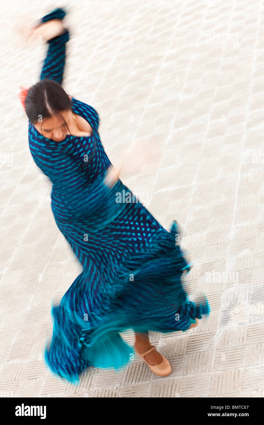 Ein verschwommenes slow-Shutter Geschwindigkeit Bewegungsaufnahme einer Frau traditionelle spanische Flamenco-Tänzerin tanzen in einem blau gepunkteten Kleid Stockfoto