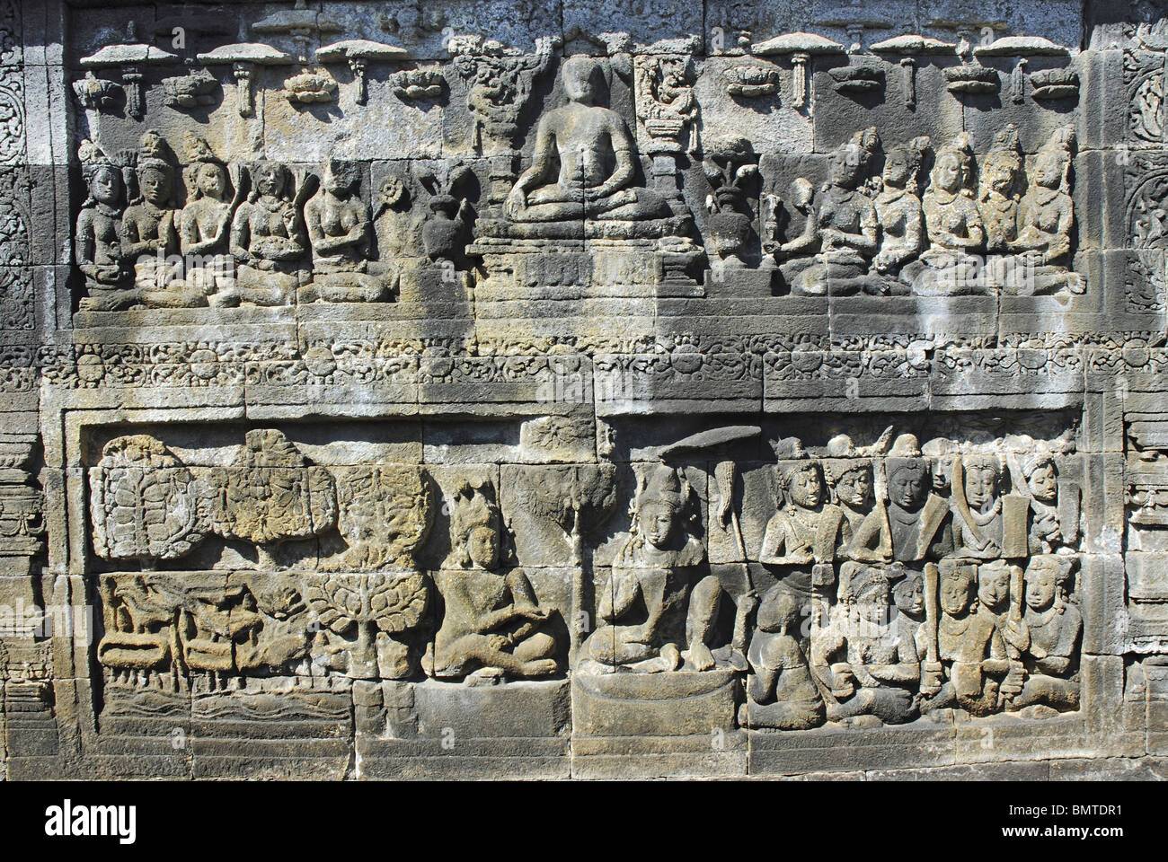 Indonesien-Java, Borobudur, oberen Panel zeigt Buddha sitzend mit Anhänger und untere Leiste zeigt König mit sitzenden Krieger, thir Stockfoto