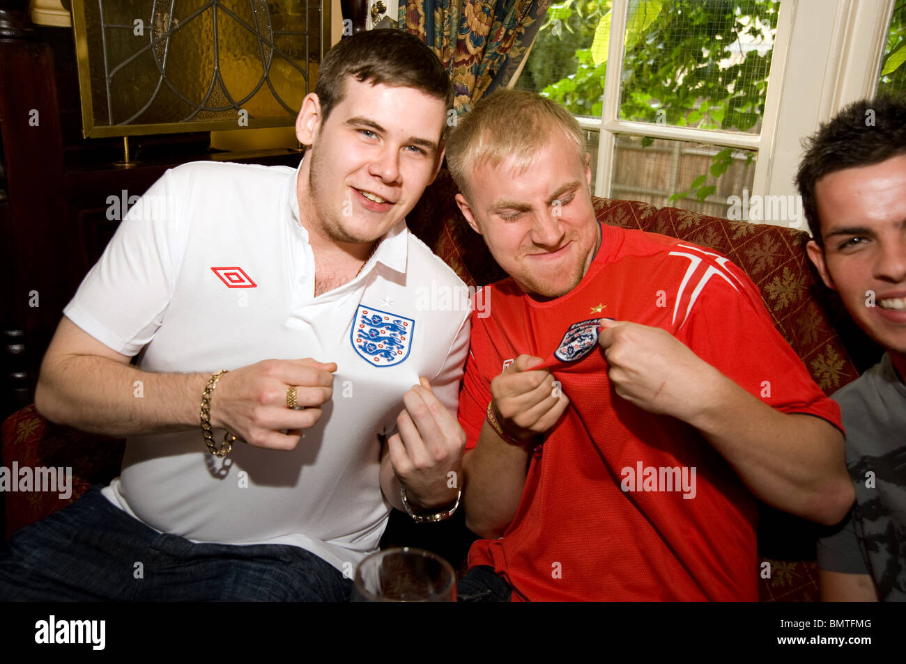 Zwei junge Männer in England Fußball-Shirts anzeigen die drei Löwen Abzeichen vor Beginn der WM 2010 Stockfoto