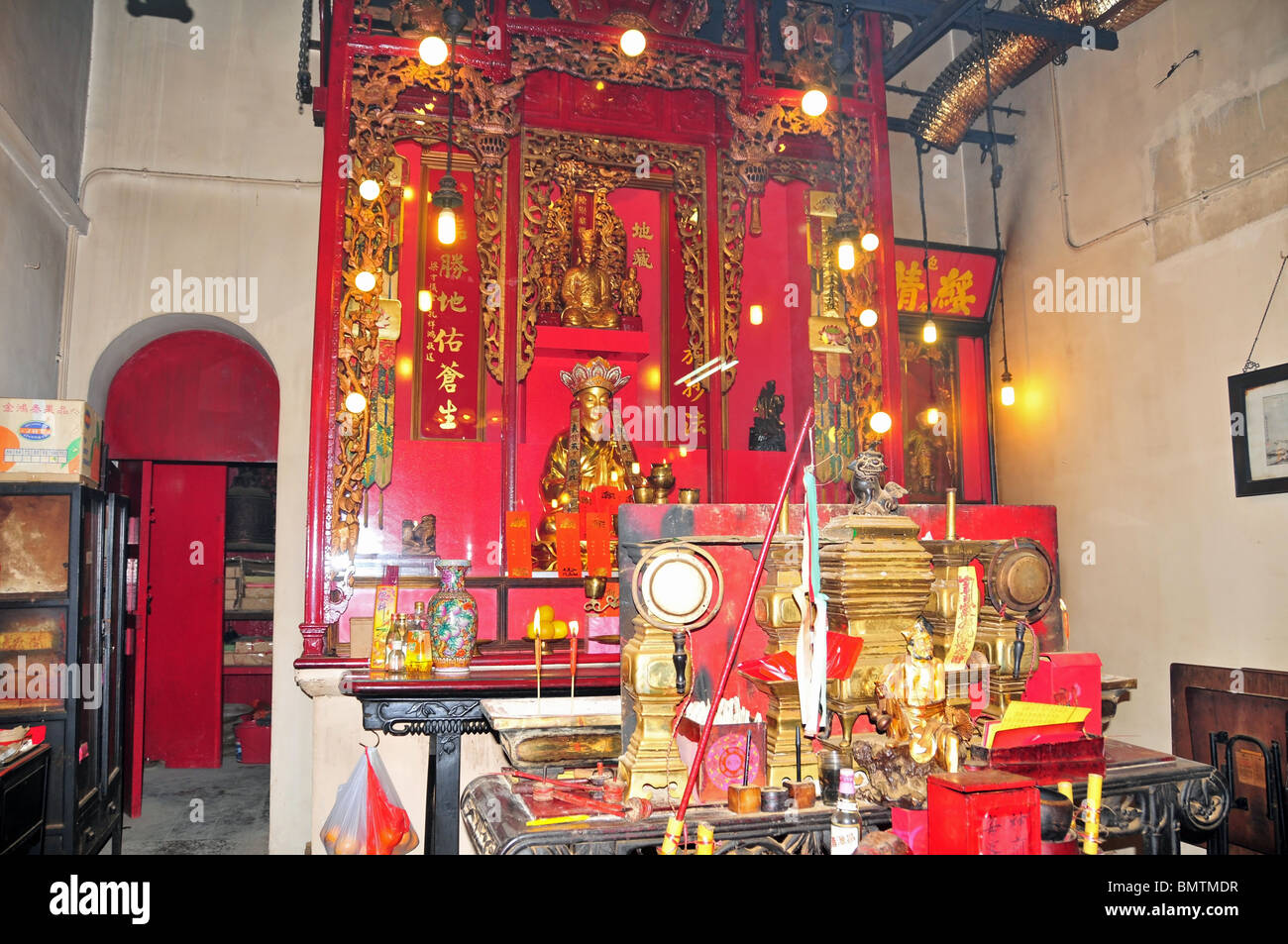 Roter Altar und gold buddhistischen Statuen im hell erleuchteten Inneren Pak Sing Ancestral Hall, Sheung Wan, Hong Kong Stockfoto