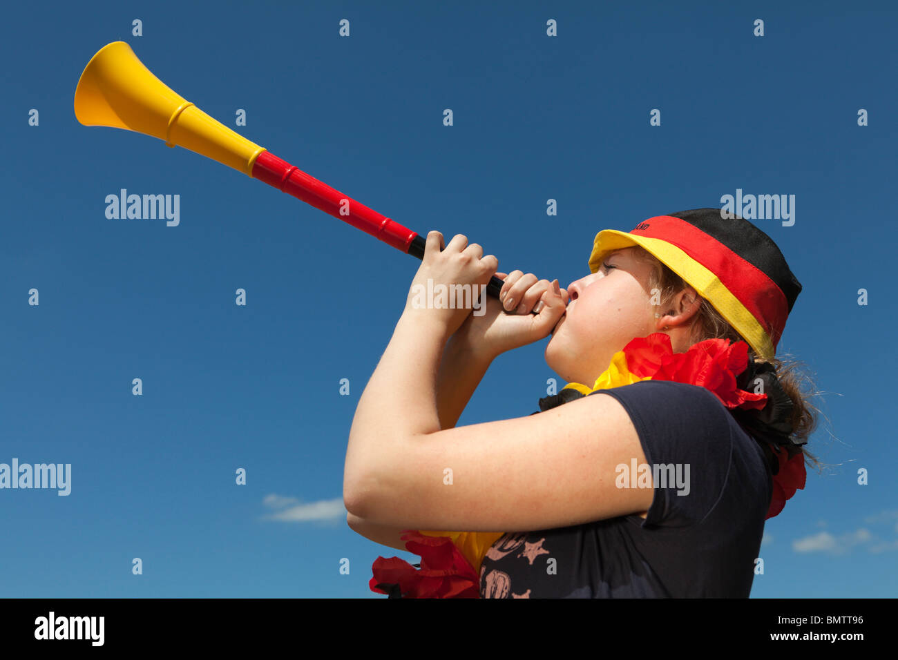 Weibliche Fußball-Lüfter bläst die vuvuzela Stockfoto