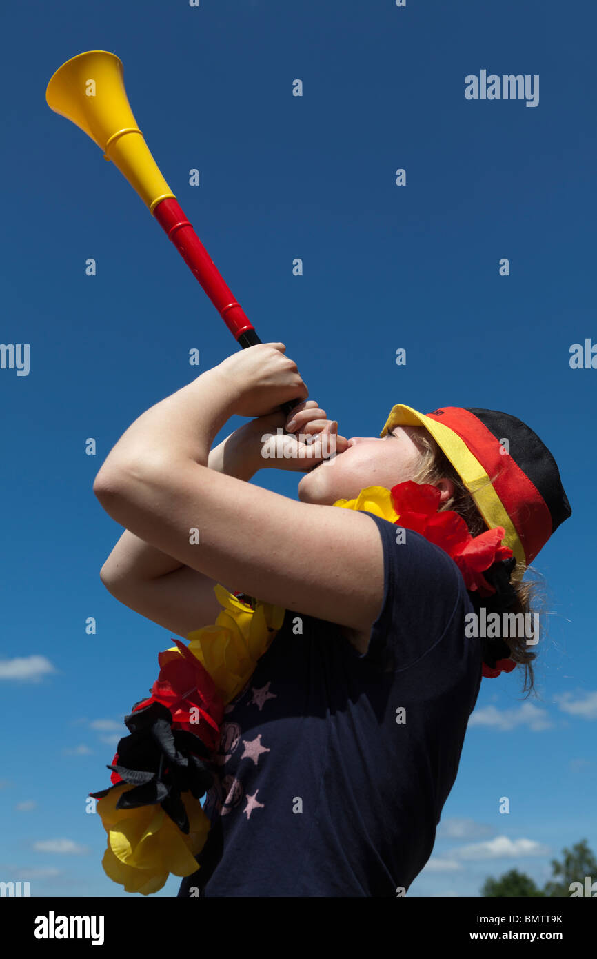 Weibliche Fußball-Lüfter bläst die vuvuzela Stockfoto