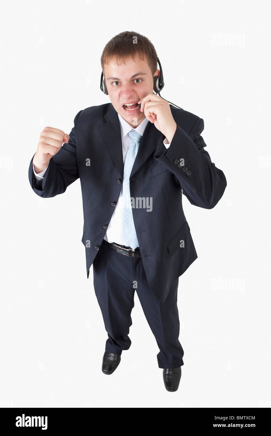 Junger Geschäftsmann mit Fäusten schreien und tragen Kopfhörer Stockfoto