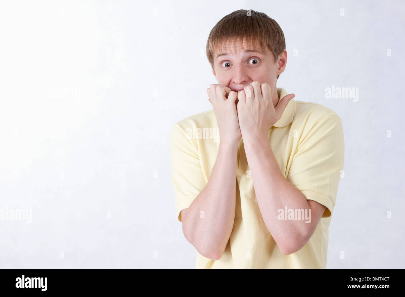 Junger Mann mit Nägelkauen schockierend Stockfoto