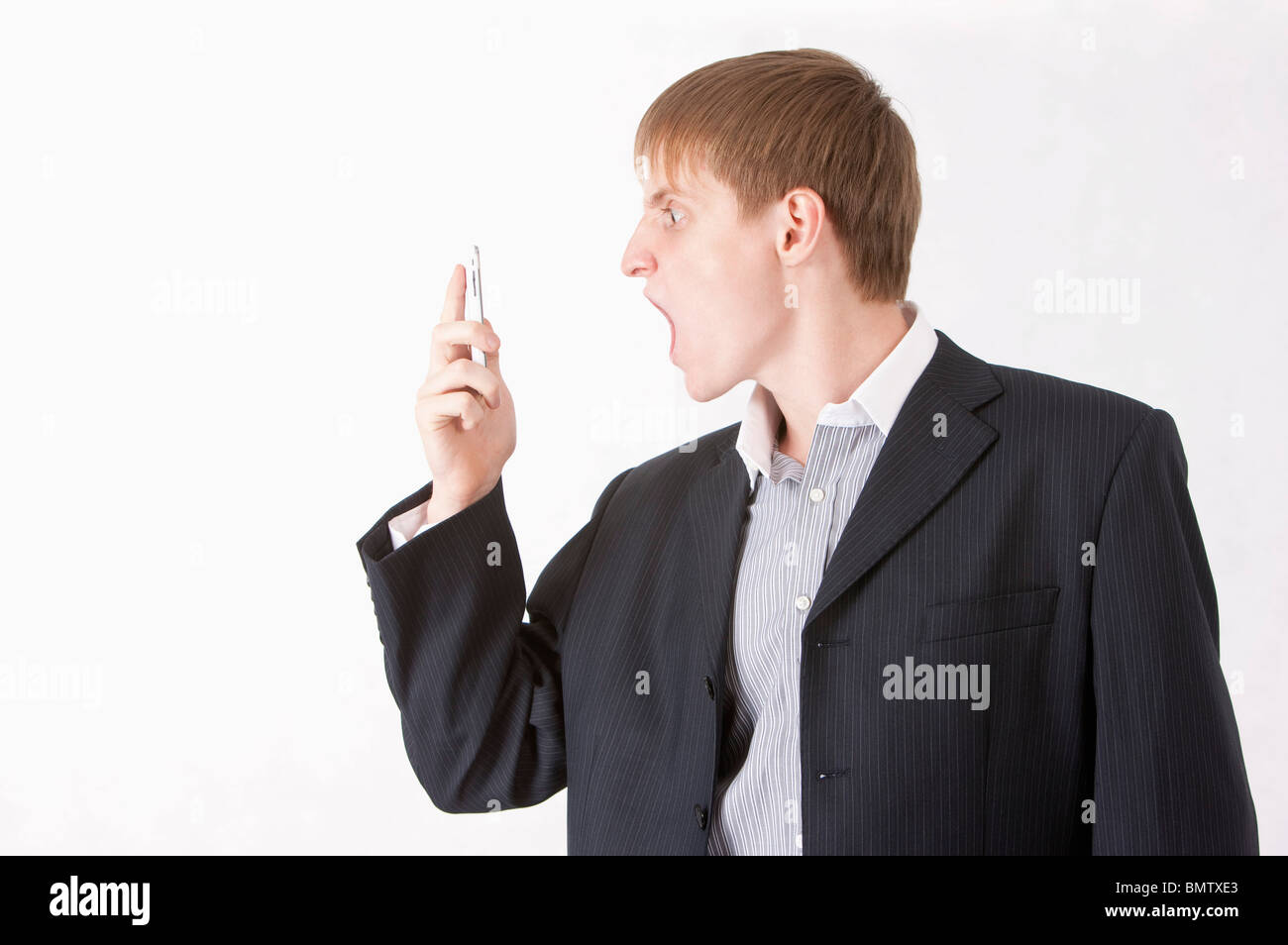 Geschäftsmann schreiend an ein Mobiltelefon Stockfoto