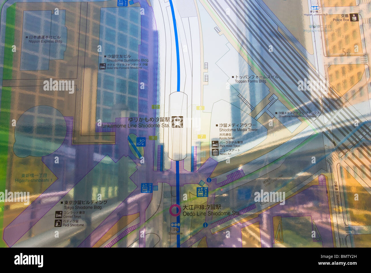 Die Yurikamome Hochbahn führt hinter Plexiglas Karte der Shiodome Sio-Site Business Complex, in Minato Bezirk im Zentrum von Tokio, Japan. Stockfoto