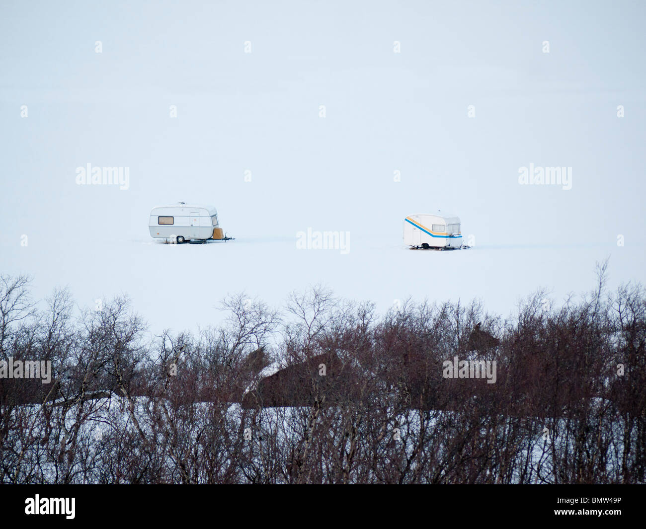 Zwei Wohnwagen stehen auf dem gefrorenen Torne Träsk See
