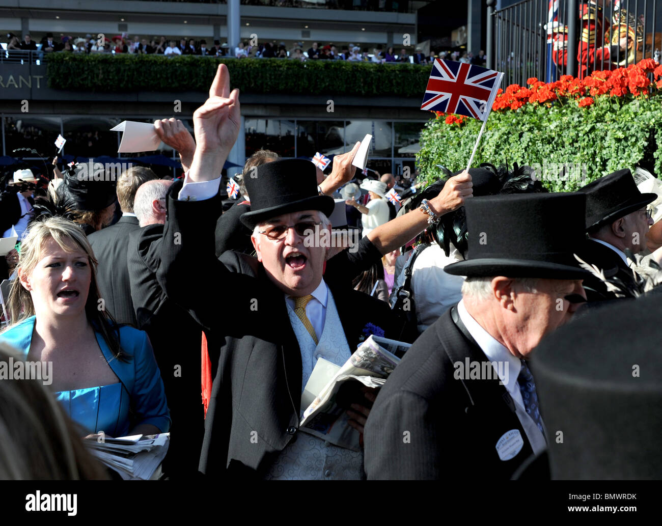 Royal Ascot Berkshire UK - lassen Sie Racegoers den traditionellen Tag Singsang an der Musikpavillon mit Union Jack-Flaggen zu wave Stockfoto