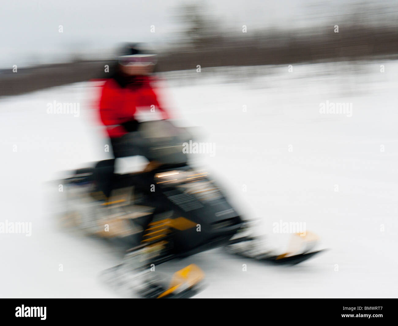Ein junger Mann fährt eine Schnee mobile durch den Schnee in Kiruna, Lappland, Nordschweden. Stockfoto