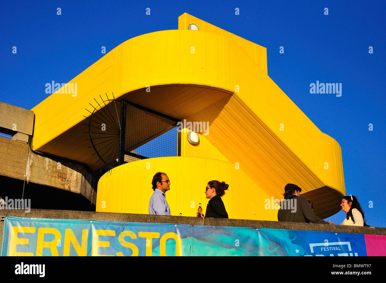 Menschen, die Geselligkeit, trinken auf dem Balkon mit abstrakten gelbe Treppe Stockfoto