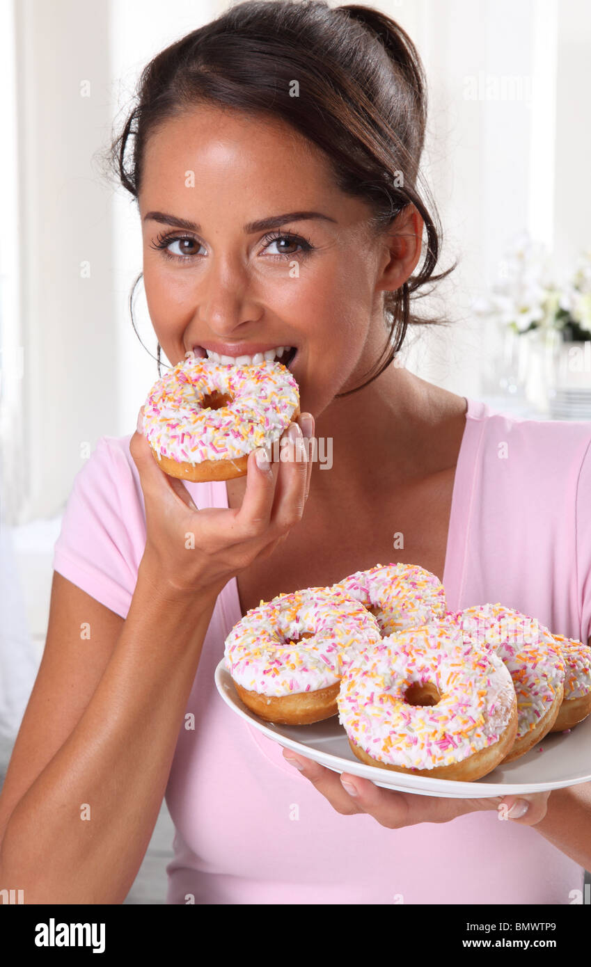 FRAU ESSEN DONUTS Stockfoto