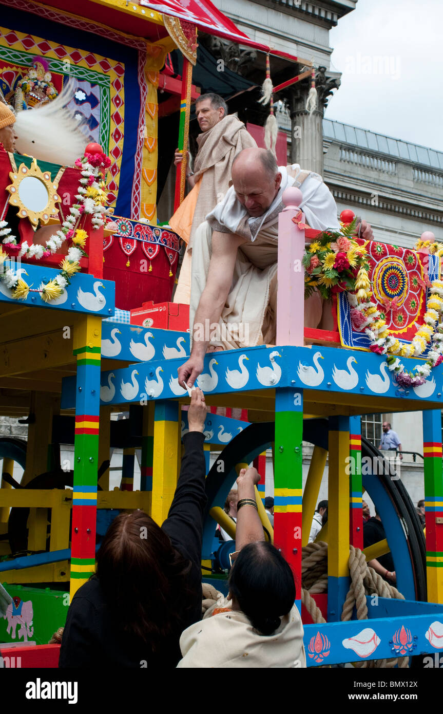 Frau gibt Geld für einen Mann auf den Wagen, Hare-Krishna-Festival der Streitwagen, Trafalgar Square, London, 20. Juni 2010, UK Stockfoto Frau gibt Geld für einen Mann auf den Wagen, Hare-Krishna-Festival der Streitwagen, Trafalgar Square, London, 20. Juni 2010, UK Stockfoto