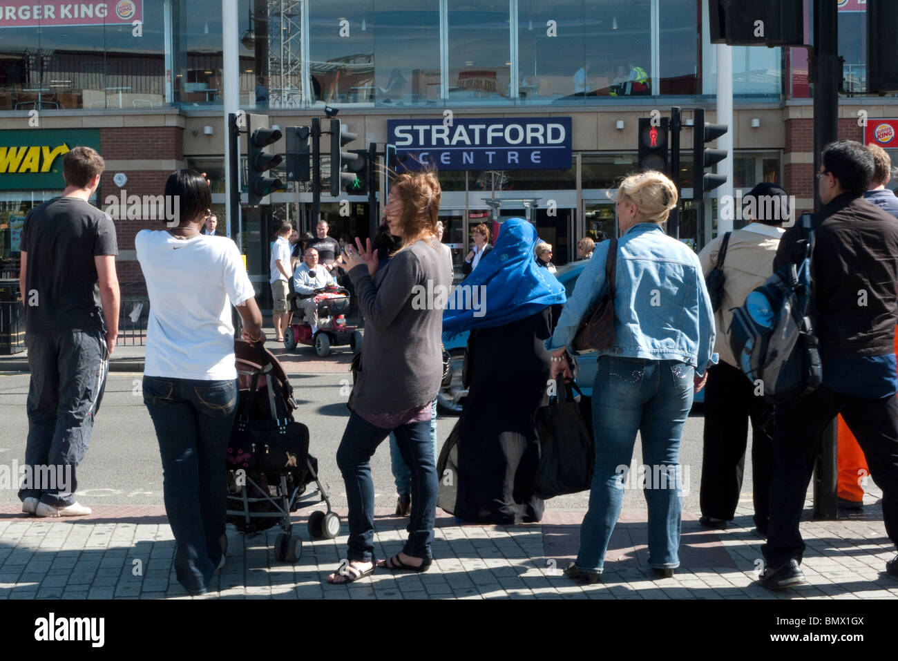 Fußgänger, die darauf warten, überqueren Sie die Straße an der Ampel Stratford Centre East London England UK KATHY DEWITT Stockfoto
