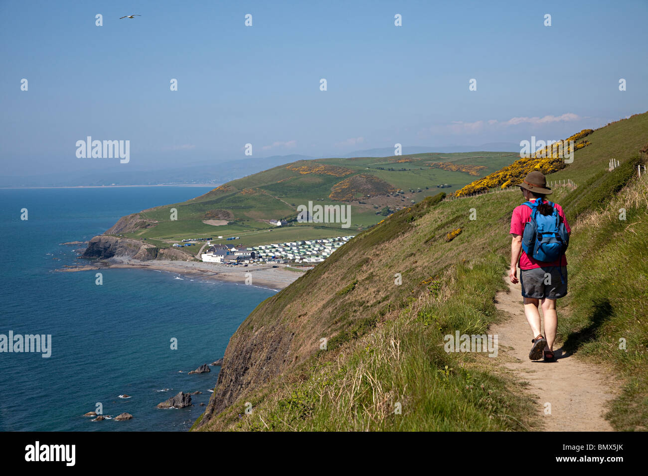 Fußgänger auf Coast Path auf Klippen mit Wohnwagen Ferienpark in Ferne Aberystwyth Wales UK Stockfoto