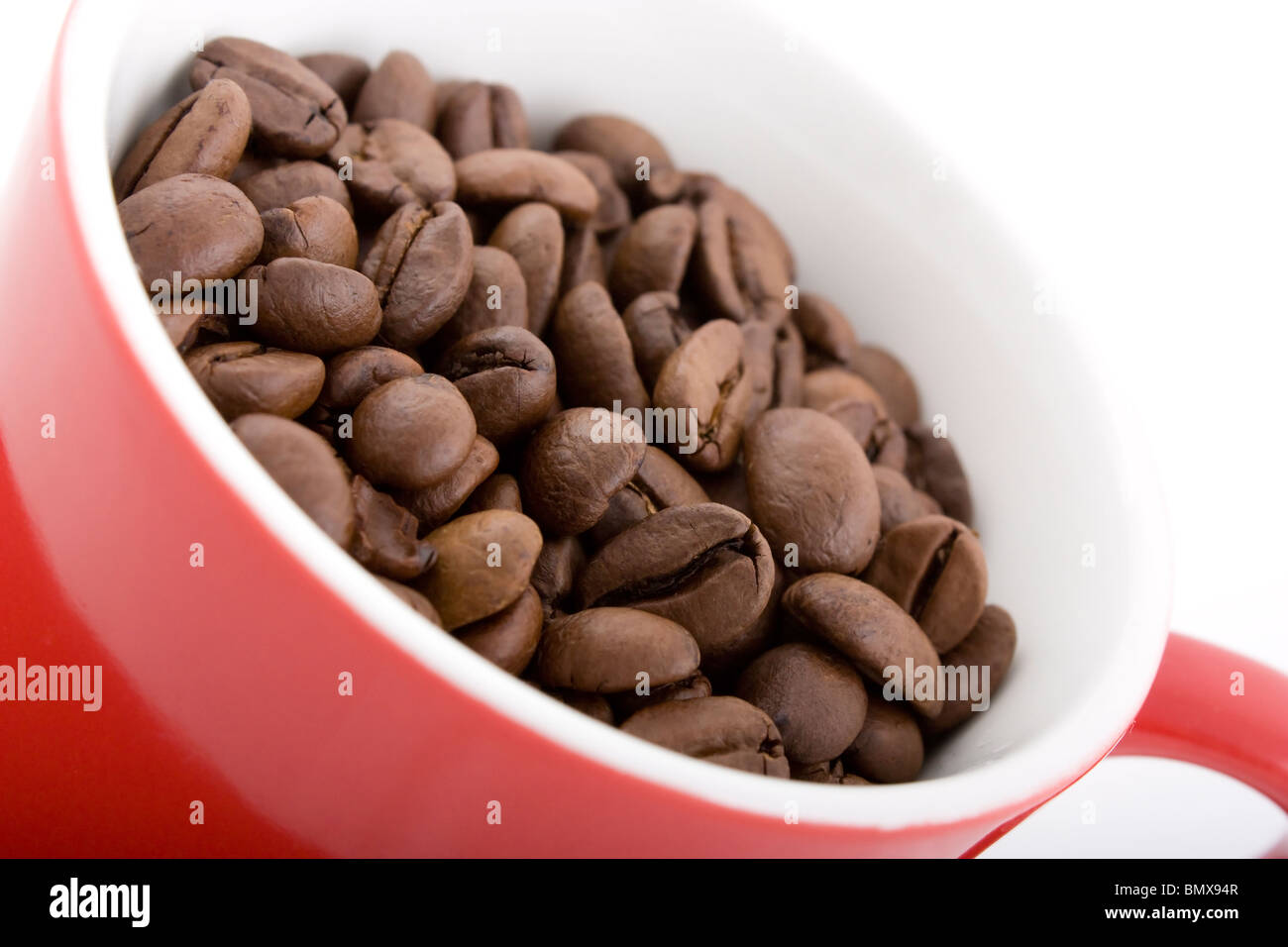 Nahaufnahme von dunkle Röstung der Kaffeebohnen in rote Tasse Stockfoto