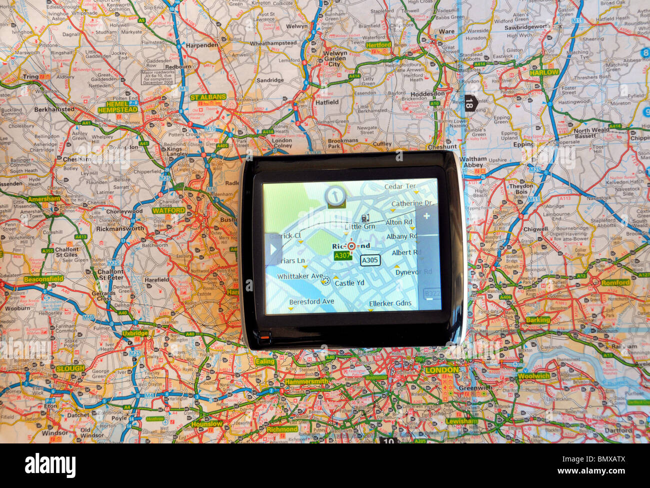 Teil einer Karte von London Straßen gesehen, sowohl auf einem Navi Bildschirm und traditionellen Fahrplan. Stockfoto